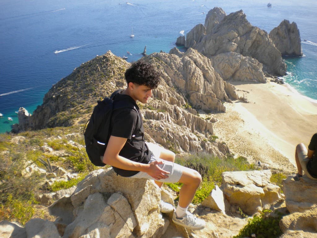 Satvik sitting above the coastline in Cabo